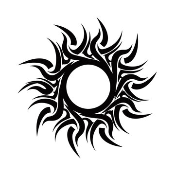 A striking black tribal sun tattoo design with a circular void in the center and sharp, flame-like rays emanating outwards.