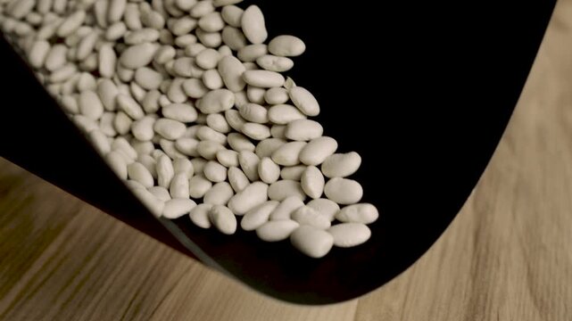 Magic_emergence_of_white_beans_on_black_background_reversed_4k_10bit
