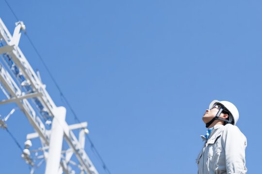 送電線を見上げる作業員