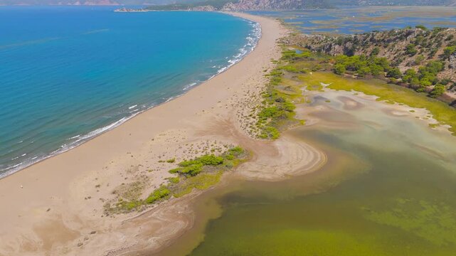 Dalyan, Turkey. Panoramic drone video of Iztuzu Beach coastline, Dalyan River mouth and mountains, perfect for travel and summer holidays in Turkey.. Aerial View