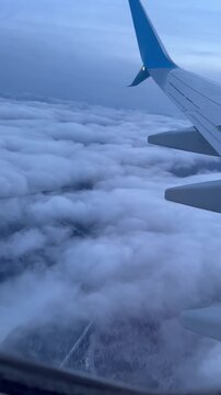 Airplane wing above clouds from window view