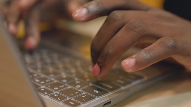 Person steadily typing code on glowing laptop under low light conditions. Focused software developer engaged in overnight coding activities using illuminated computer in quiet environment