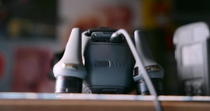 Hand connecting a power cable to a drone battery for charging