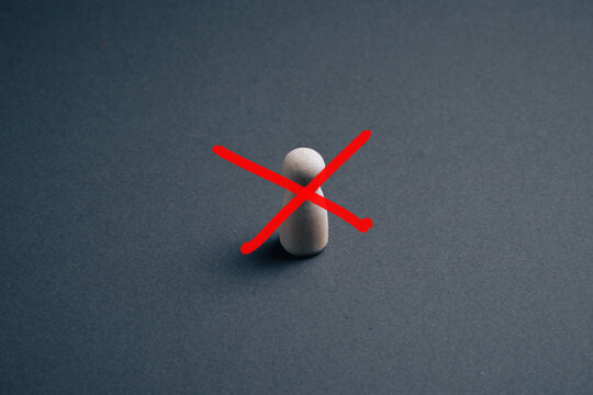 Rejected candidate concept with wooden peg figurine crossed out by red X mark, symbol of exclusion, rejection and ban on a minimal dark background with copy space