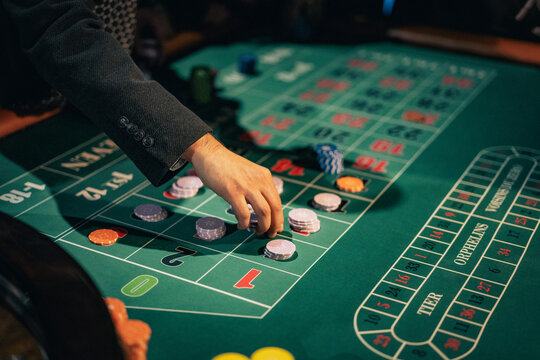 Close view of player placing chips on roulette table in casino environment. Gambling, risk and luck concept.