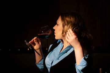 Fototapeta premium Woman sommelier sniffing red wine aroma for professional flavor assessment. Olfactory analysis and expert evaluation of vineyard product.