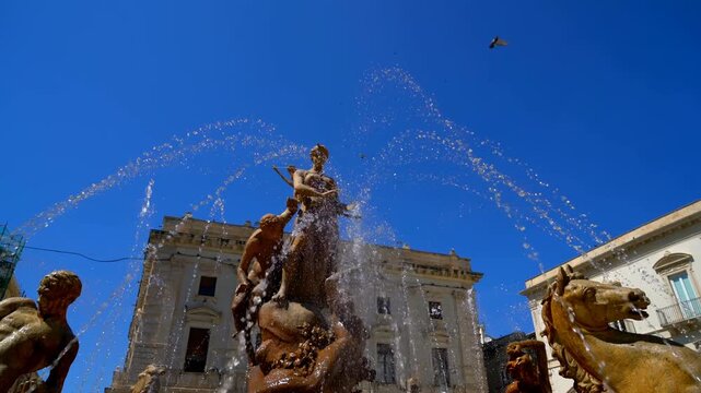 Syracuse, Sicily, Italy. Diana Fountain - Classic fountain with a statue of the goddess of the hunt Diana, created in 1907 by sculptor Giulio Moschetti. Sunny summer day