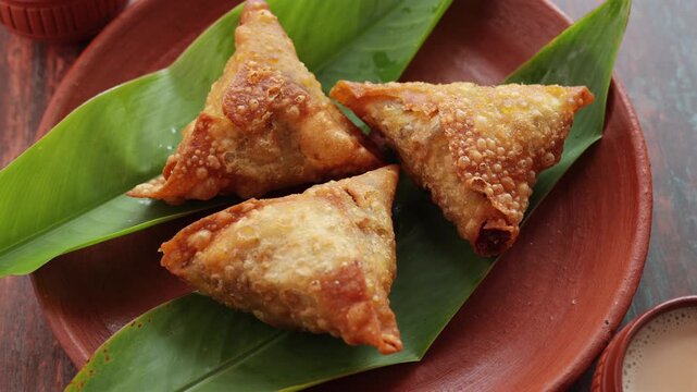 Assorted Kerala snacks Ulli vada spicy onion fritters  Parippu Vada or Paruppu Vadai made with toor dal Samosa crunchy triangular shaped wraps Neyyappam bonda and milk tea undampori. 