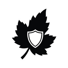 Obraz premium Black silhouette of a leaf with a white shield emblem in the center