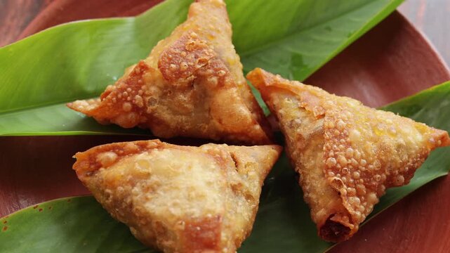 Samosa crunchy triangular shaped wraps stuffed with spicy vegetables. Cocktail mini triangle Kerala samosa made using patti or strip. Popular home made snack from India	
