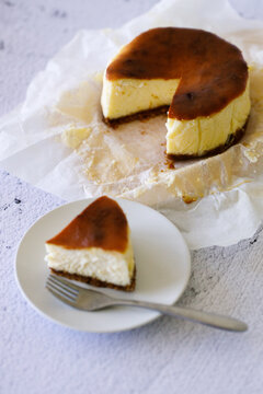 Cheesecake with baking paper on white marble table.