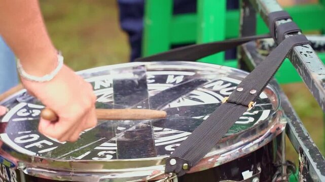 Hands striking a drum with mallets, creating rhythmic beats. Ideal footage for music, performance, and festival atmosphere.