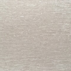 Fototapeta premium Textured surface showing light gray tones with subtle patterns at a close range during daylight