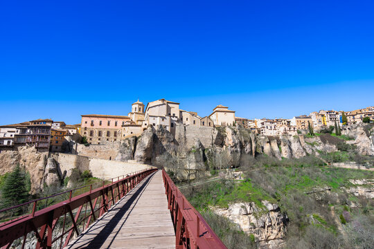 A view of the iconic red iron San Pablo Bridge spanning the Huecar Gorge, connecting the historic city of Cuenca to the monastery in Spain.