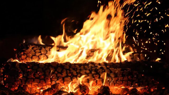 Burning firewood with glowing flame and sparks off grid creates warm summer nights perfect for travel adventure and outdoor