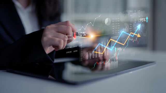 Businesswoman interacts with a tablet displaying dynamic graphs and charts that represent financial growth and analysis in a sophisticated business environment. Scalp