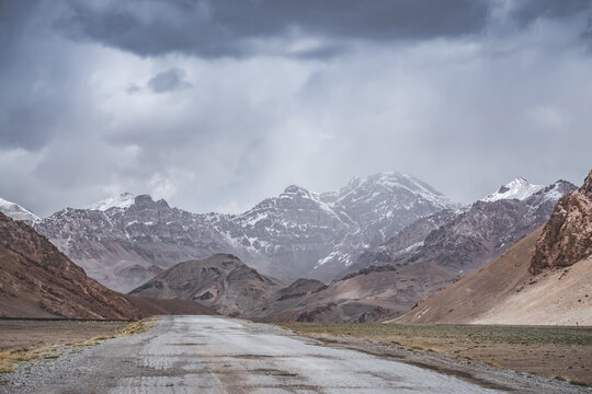 The Pamir Highway in the Tien Shan highlands of Tajikistan, a landscape with a road in the Pamirs, a road stretching into the distance against a backdrop of mountains