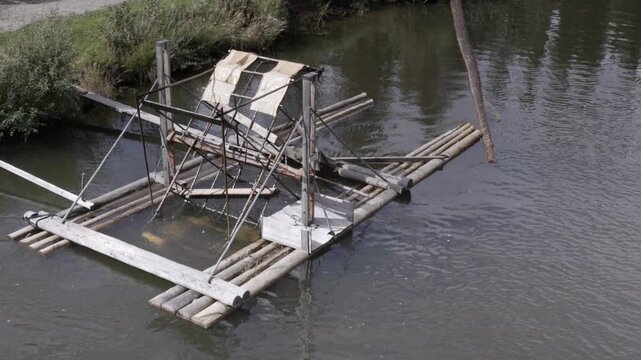 a high angle shot of a rotating fish wheel used to catch salmon on the chena river near fairbanks, alaska of the usa