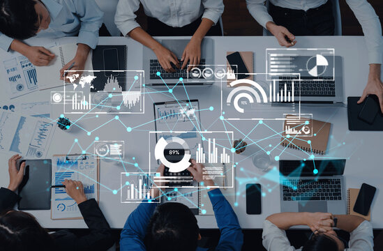A modern office scene showcasing a collaborative team engaged in data analysis, using laptops and displaying graphical statistics for informed decision-making. Trope