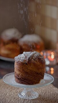 Slow motion shot of icing sugar falling down on a fresh cruffin pastry