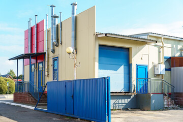 Naklejka premium Ventilation pipes on the facade of the building. Shiny metal pipes, covered with a thermal shell, in the ventilation system of the building.