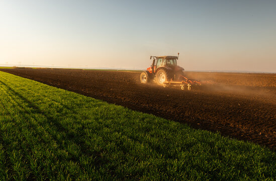 Farmer in tractor preparing land for sowing