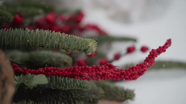 Closeup red amaranth on pine branches with scattered berries, shallow depth of field and crisp winter light, kraft wrapping edge in frame, styling scene for holiday centerpiece or present design,