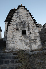 Fototapeta premium Close-up of an ancient stone crypt with a stepped pyramidal roof in the Dargavs necropolis, North Ossetia-Alania.
