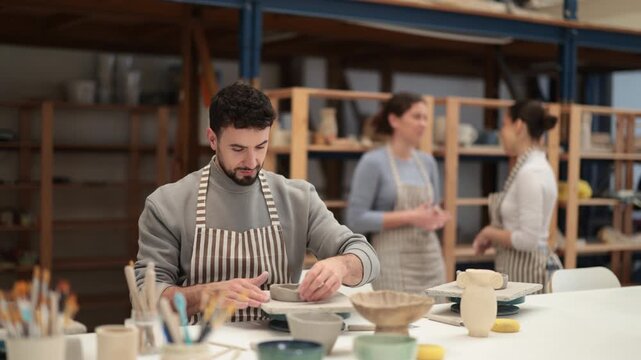 Man at table molds cup from wet clay in a pottery workshop. High quality 4k footage