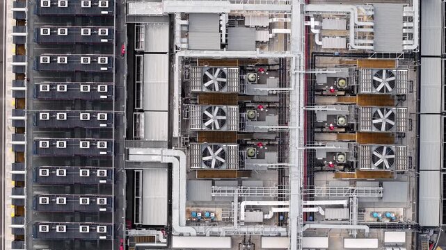 Aerial view of a large cooling system in a data center. Rows of servers and industrial fans dominate the scene