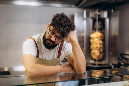 Tired chef experiencing burnout working at fast food restaurant