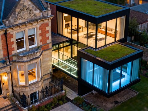 Juxtaposition of historic Victorian house with modern glass and green roof extension in England siyam