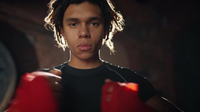 Self-confident fighter looking at camera and showing forward by index finger. Call rival to fight and challenge, do sport and be powerful, african american young man in gym, strong look, champion