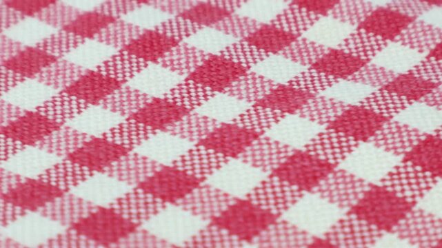 Red and white checked cotton fabric rotates on the table