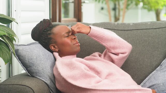 Young African American Woman Suffering From Headache Or Sinus Pressure While Resting At Home