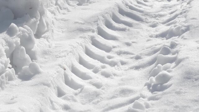 A close-up of truck tire tracks. Deep tire marks from a heavy vehicle in the snow. Winter background.