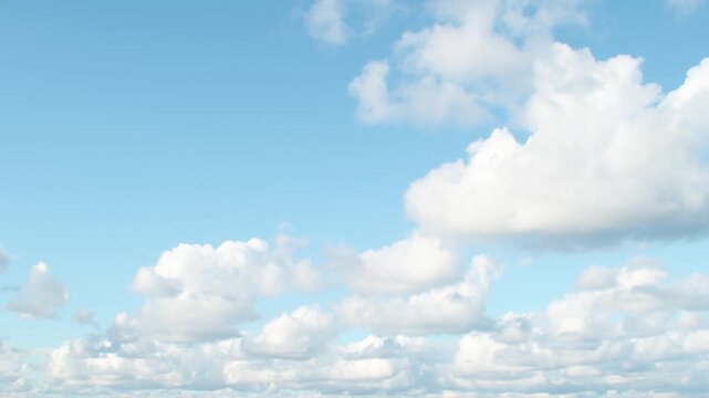 A dramatic expanse of gray clouds set against a brilliant blue sky. The clouds exhibit a textured, layered appearance, suggesting a dynamic weather pattern.