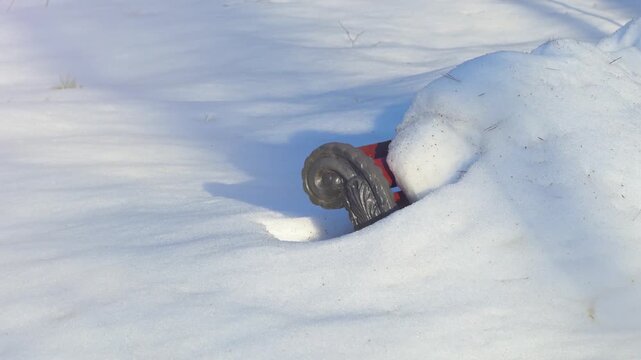 A park bench covered in deep snow. Part of the bench's back is visible through the snow. Heavy precipitation during winter.