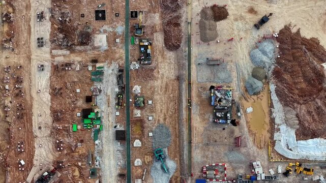 Aerial view of active construction site. Earth movers and workers shape new infrastructure.