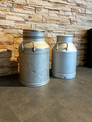 Obraz premium selective focus two vintage milk cans side by side in rustic setting