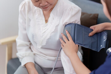 Nurse measuring blood pressure of elderly woman