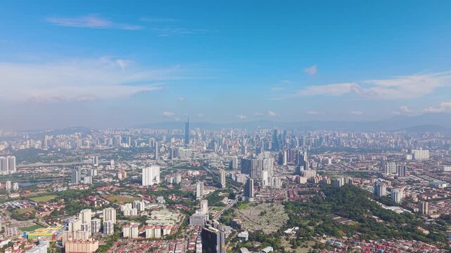 Expansive drone shot of Kuala Lumpur skyline from Cheras district on a sunny day, showcasing modern high-rise buildings, urban density, and vibrant city landscape in Malaysia. UHD.