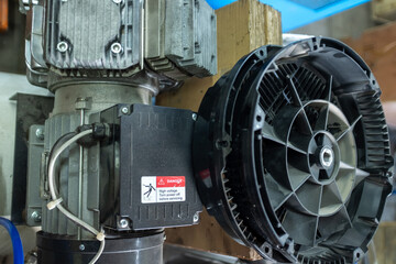 Fototapeta premium Detailed top view of an air compressor assembly featuring a white multi-blade cooling fan, aluminum cylinder head with cooling fins, and high-pressure copper piping with electrical wiring