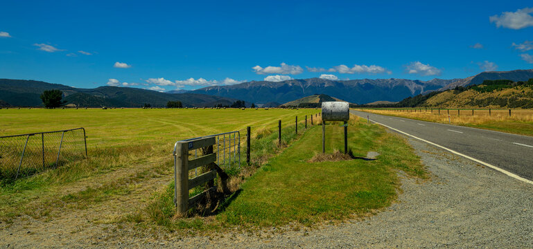 Rural road with hay bales and mountains