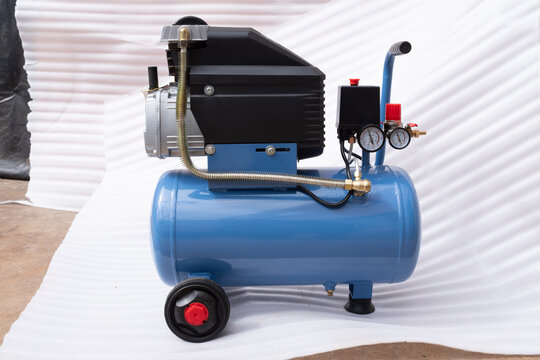 Portable direct drive oil-lubricated piston air compressor with blue tank, black protective motor cover, dual pressure gauges, and ergonomic transport handle on white