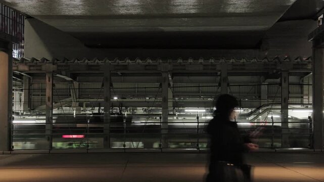 Night in Tokyo : People Passing Through on the Pedestrian Deck Beside the Station Platform With a Commuter Train Arriving in the Background  |  Shibuya Station Area, Shibuya, Tokyo, Japan