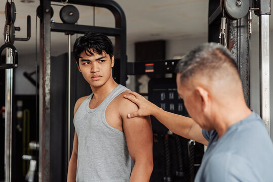 A coach assess shoulder development to his client, giving honest critical tips and improvements. Giving feedback to current progress.