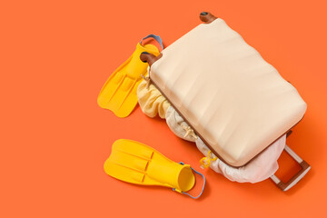 Suitcase with flippers on orange background © Pixel-Shot