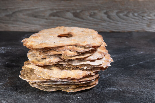 Angled view of stacked rustic crispbread on slate surface