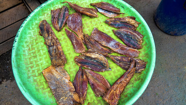 Different types of salted fish and smoked fish to the markets of Java Island. Fish on a bamboo straws platter (traditional tableware)